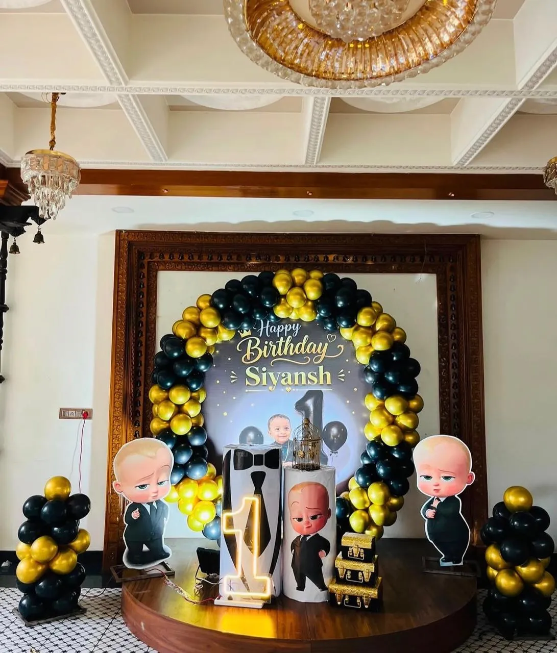 Baby boss ring decor with themed backdrop , cake table, 1 neon light and 2 baloon pillars.